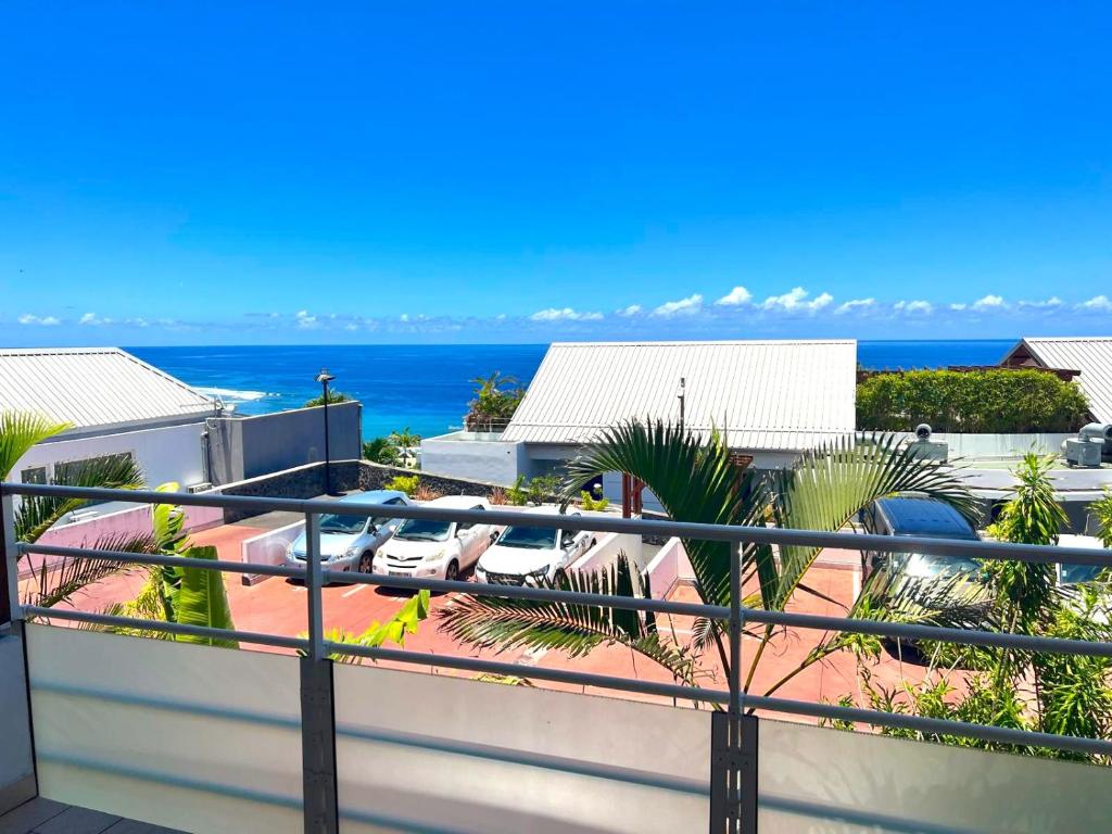 a balcony with a view of the ocean at Le Blue Ocean - vue mer - parking - clim - wifi in Saint-Gilles-les-Bains