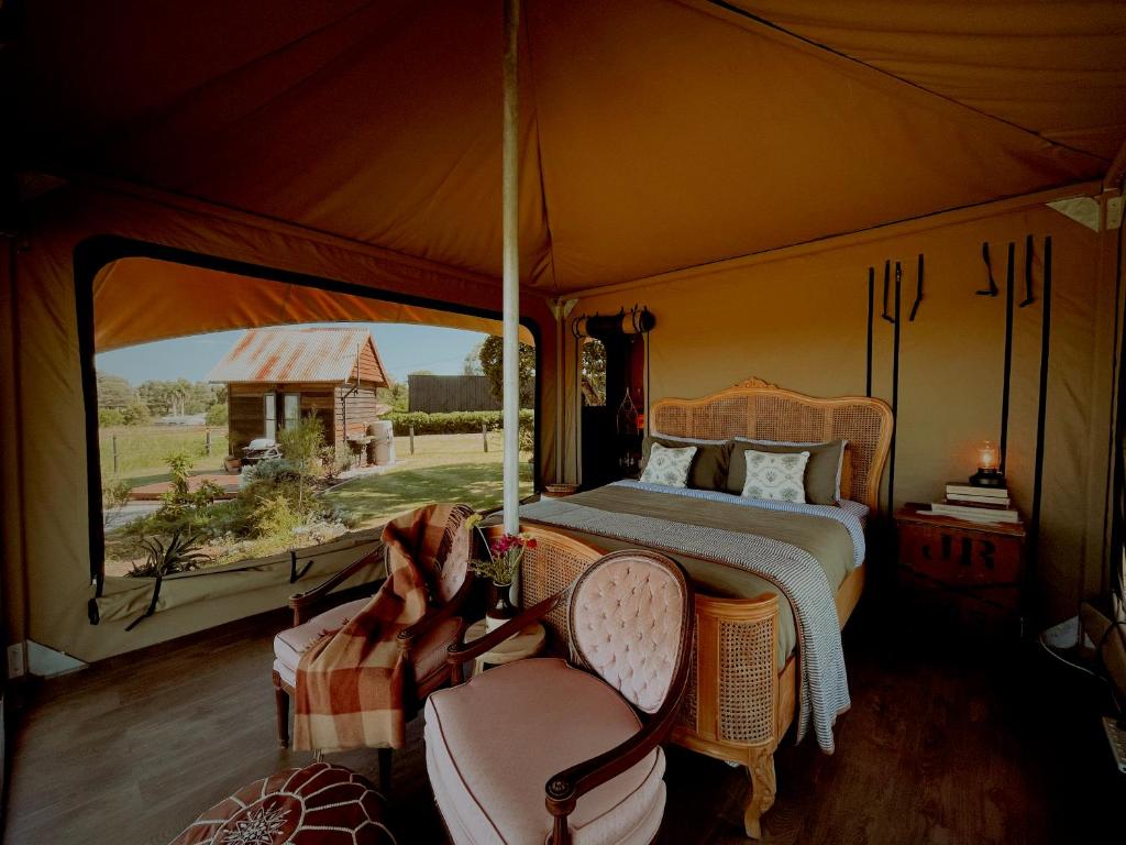 a bedroom with a bed and a large window at The Forager Glamping at Twigley Farm in Marburg