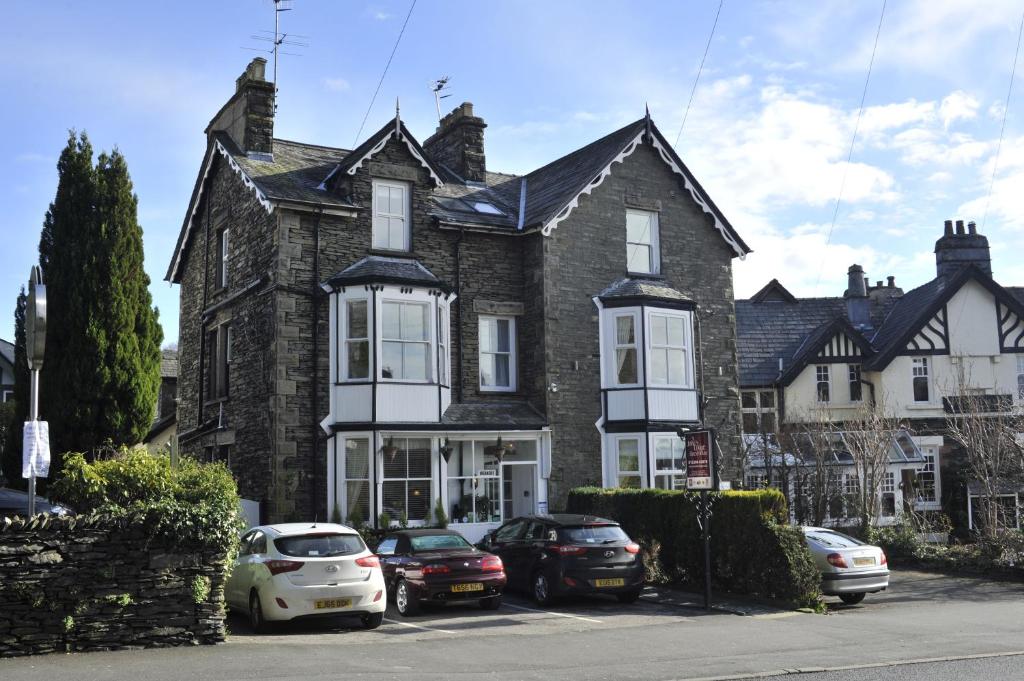 a large brick house with cars parked in front of it at St John's Lodge incl off-site leisure club in Windermere