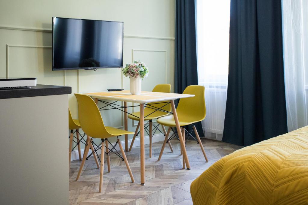a room with a table and chairs and a tv at Petite Visite No 18A i 18B in Toruń