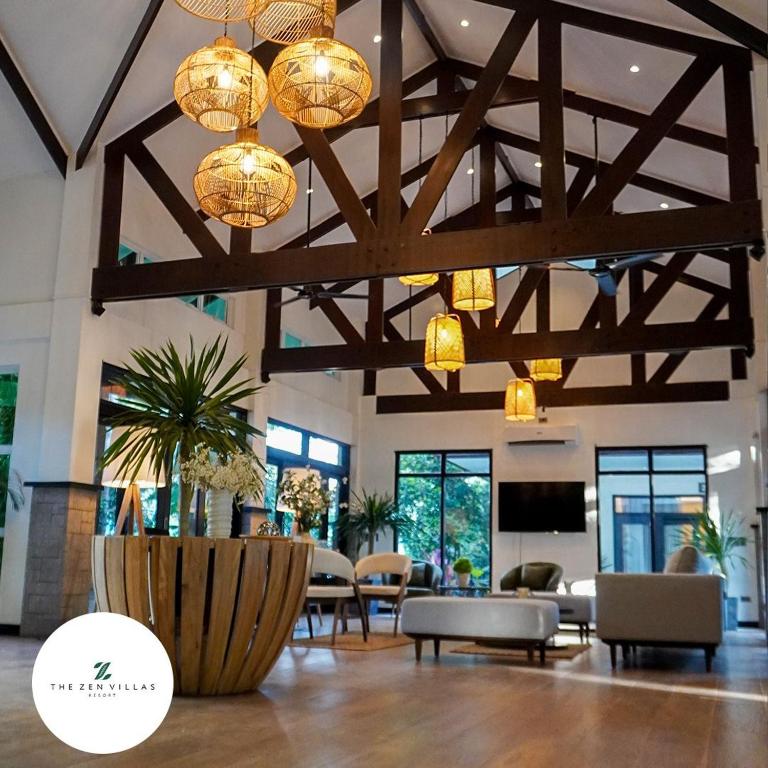a lobby with tables and chairs and chandeliers at The Zen Villas Resort in Lipa