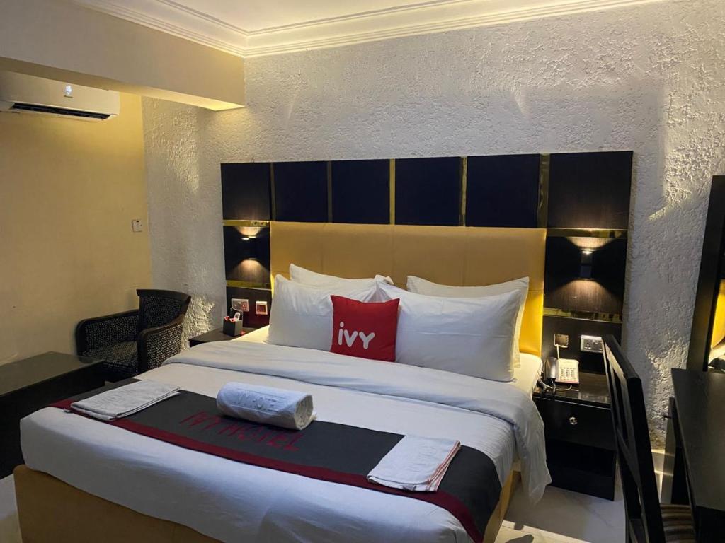 a hotel room with a large bed with red pillows at Aotel Hotels & Suites - Ojota in Lagos