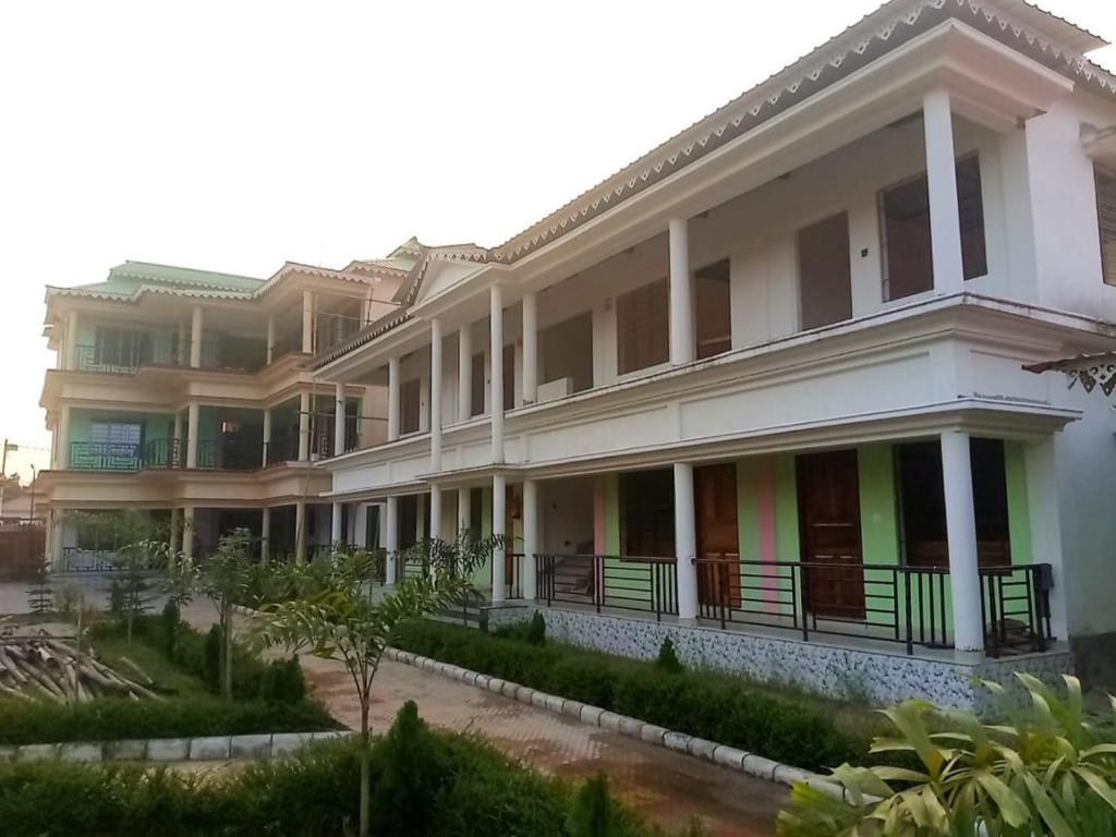 un grand bâtiment blanc avec beaucoup de fenêtres dans l'établissement Kanchenjunga View Mansions By StayApart, à Lataguri