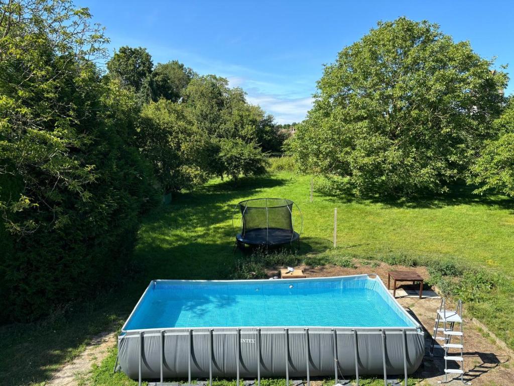une piscine vide dans une cour arborée dans l'établissement Le bonheur est dans le perche, à Saint-Jouin-de-Blavou