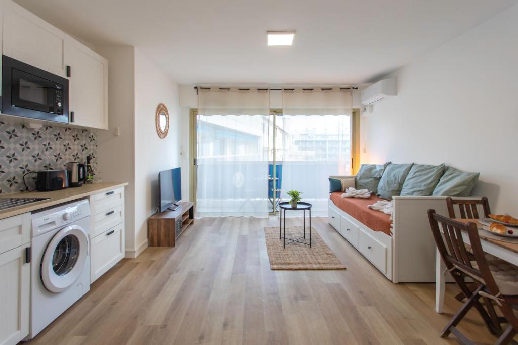 Il comprend un petit salon avec un lit et une cuisine. dans l'établissement A1 - Studio Antibes Centre 5 min to Sea - AC & Balcony, à Antibes