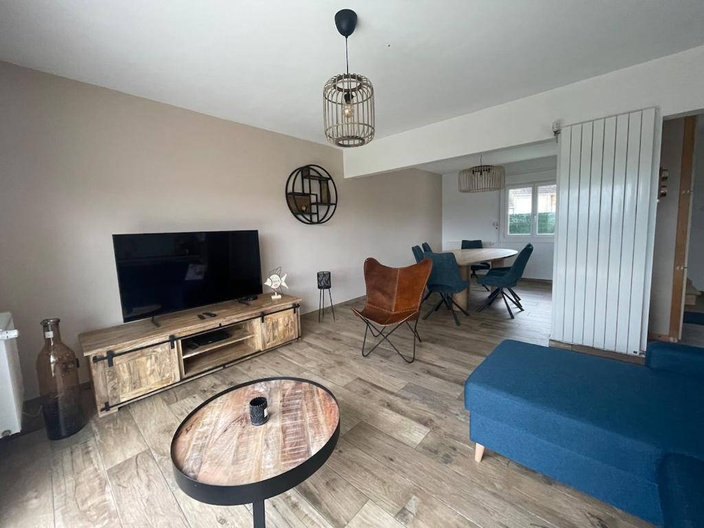 un salon avec un canapé bleu et une télévision dans l'établissement La Wimereusiènne, à Wimereux