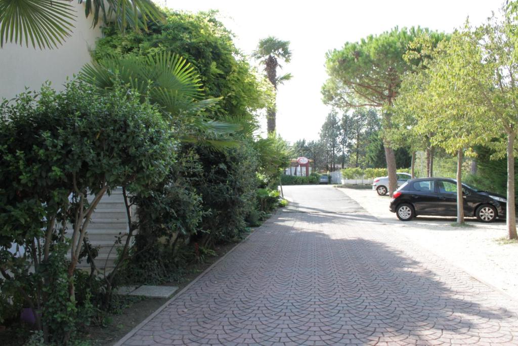 a street with trees and a car parked on the street at Hotel Ristorante Fortuna in Cavallino-Treporti