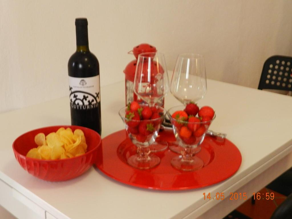 a red tray with a bottle of wine and a bowl of fruit at La Quiete in Beverino