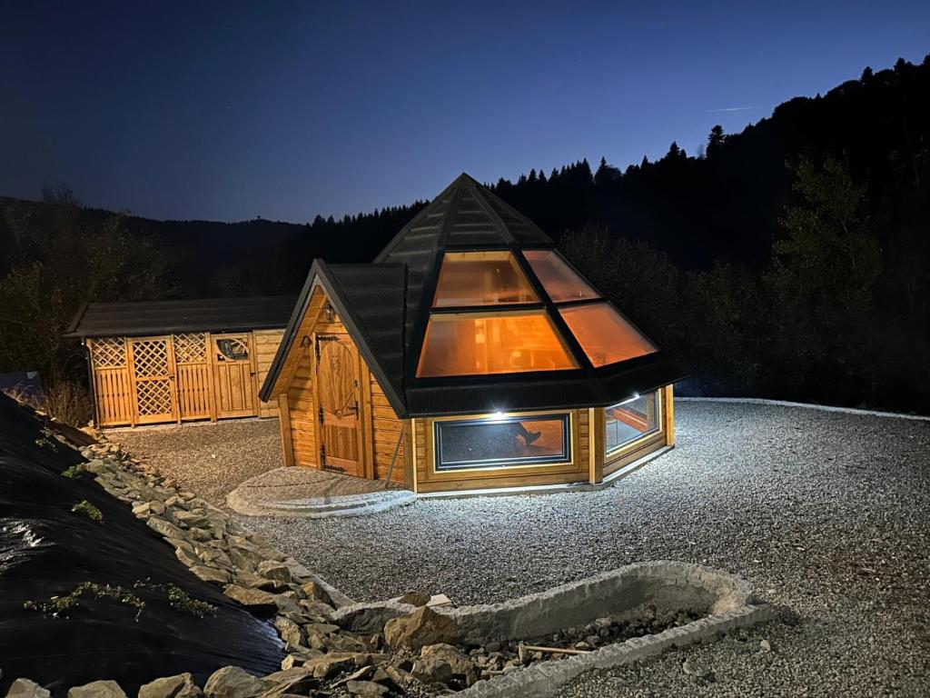 a small house with a glass roof on a gravel lot at Sferyczny Azyl in Muszyna