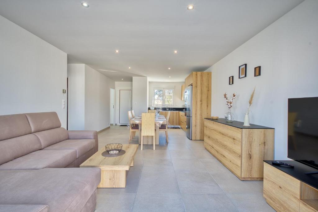 un salon avec un canapé et une table dans l'établissement Maison Corail 1 - Climatisation jardin et parking, à Saint-Pierre-dʼOléron
