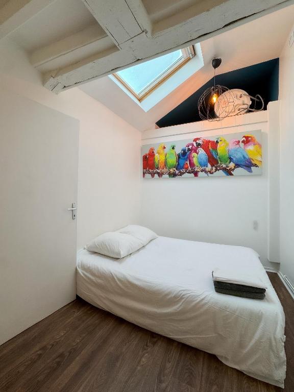 une chambre avec un lit et un tableau au mur dans l'établissement Artemis, à Caen