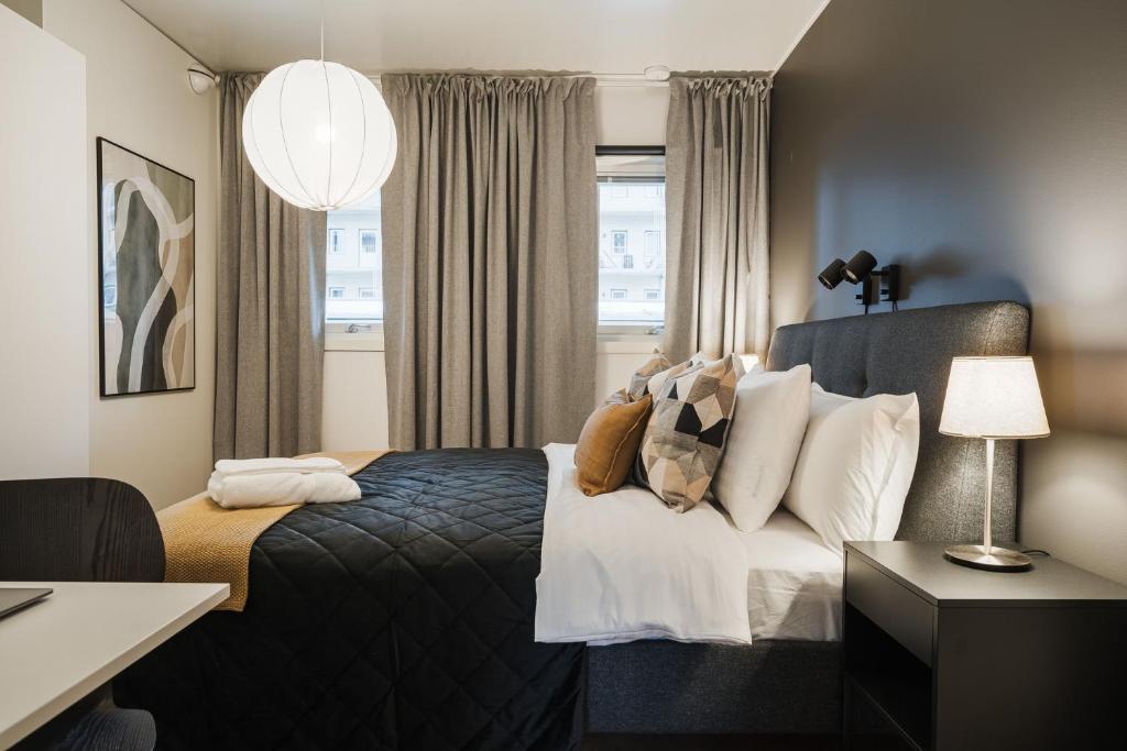 a hotel room with a bed and a window at Guestly Homes - 1BR Scandinavian Comfort in Piteå
