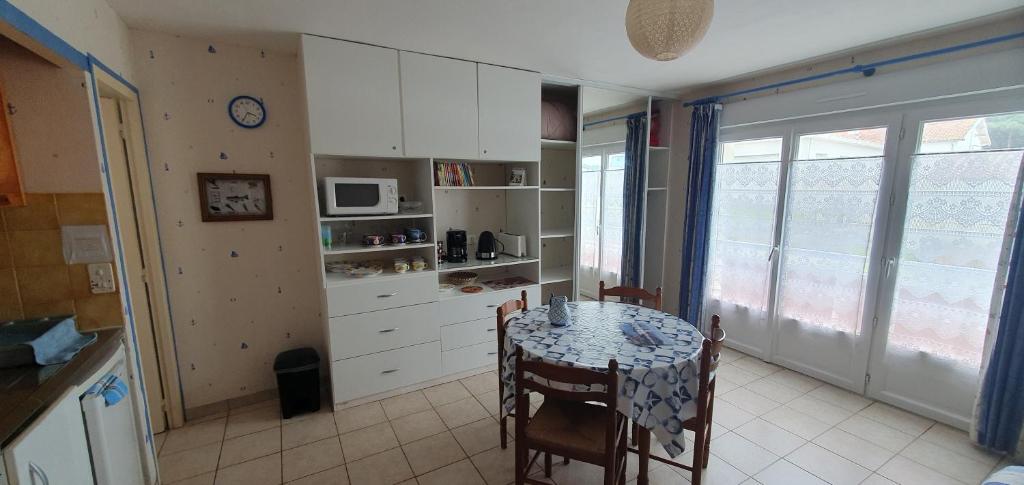a kitchen with a table and chairs and a kitchen with a table and a kitchen at studio 2 pers Fromentine centre in La Barre-de-Monts