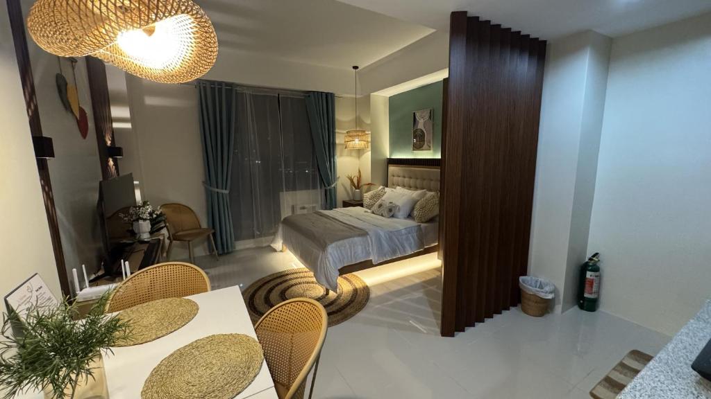a bedroom with a bed and a table and chairs at Slai Staycation Near Mactan Newtown in Lapu Lapu City