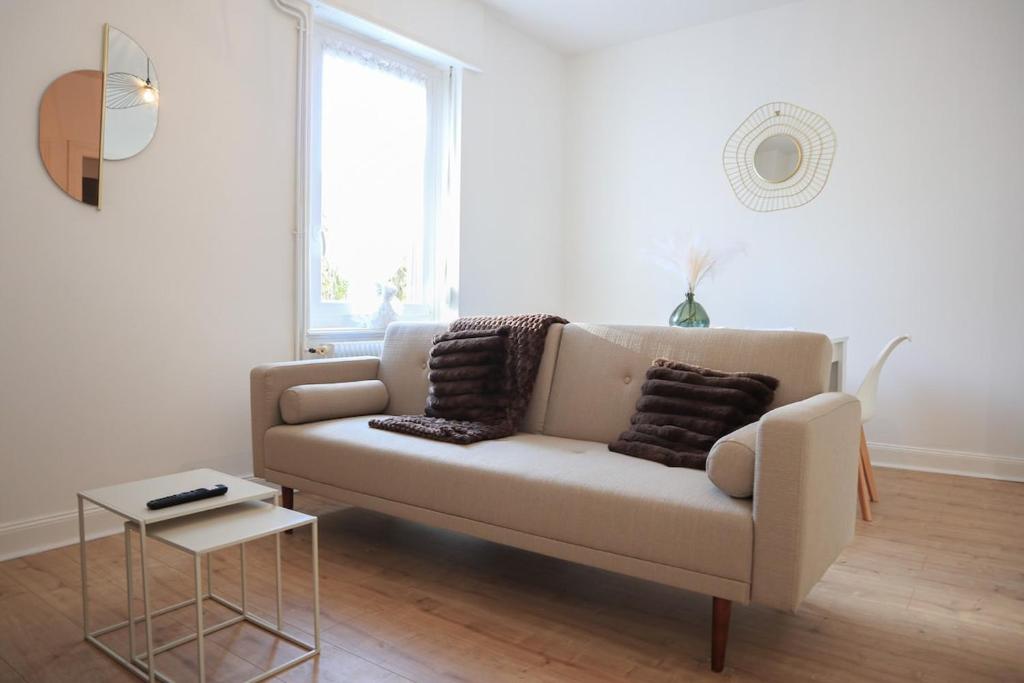 un salon blanc avec un canapé et une table dans l'établissement La Maison du temps ensemble, à Mulhouse