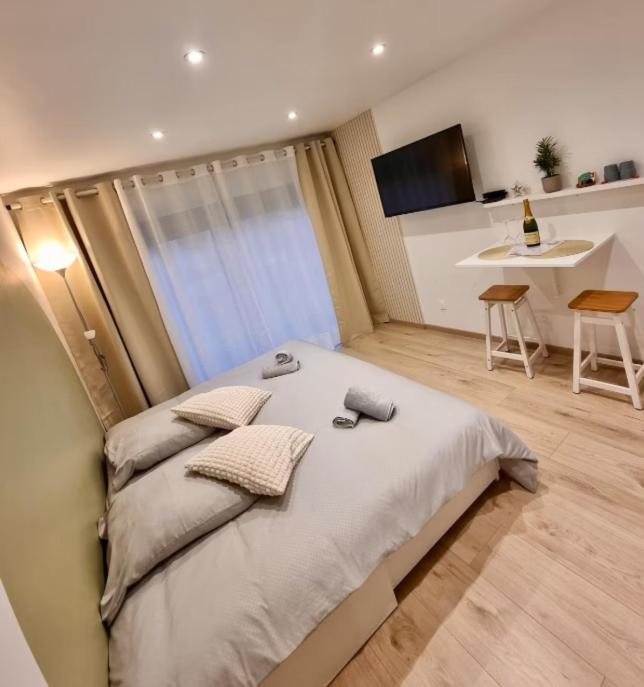 une chambre avec un lit et une cuisine avec une table dans l'établissement Suite cosy indépendante Évasion 2 proximité Colmar, à Wintzenheim