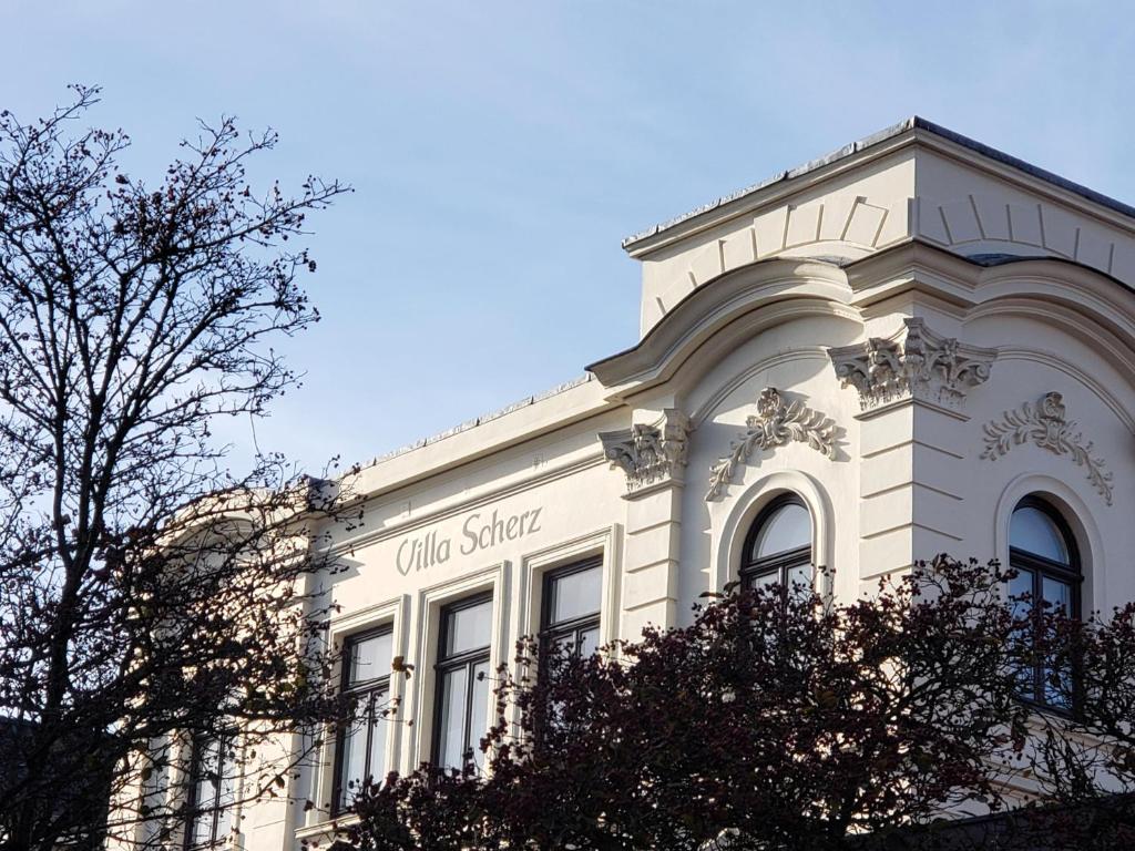 a white building with a sign on the side of it at Villa Scherz - stilvoll, zentral, ruhig, EG in Borkum