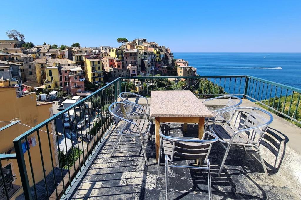 a table and chairs sitting on top of a balcony at Isola Apartment with terrace and Stunning sea view in Corniglia
