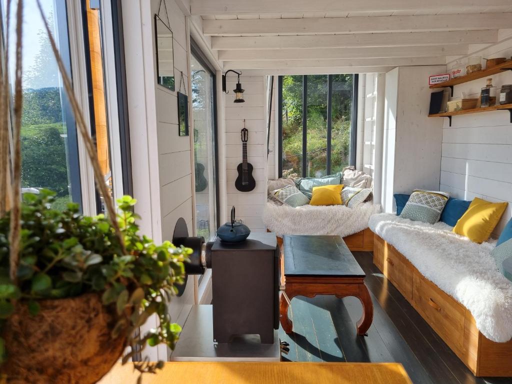a tiny house with a couch and a table at Tiny House, Hautes Vosges in Saint-Maurice-sur-Moselle
