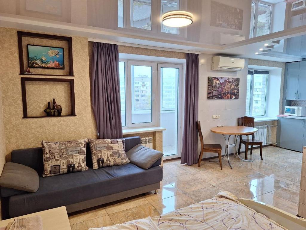 ein Wohnzimmer mit Sofa und Tisch in der Unterkunft 1-комнатная на левом берегу Днепра in Dnipro