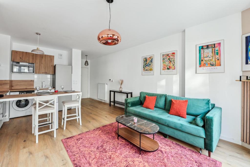 un salon avec un canapé bleu et une cuisine dans l'établissement Cours des Lavandières - Joli T2 proche Paris, à Saint-Ouen