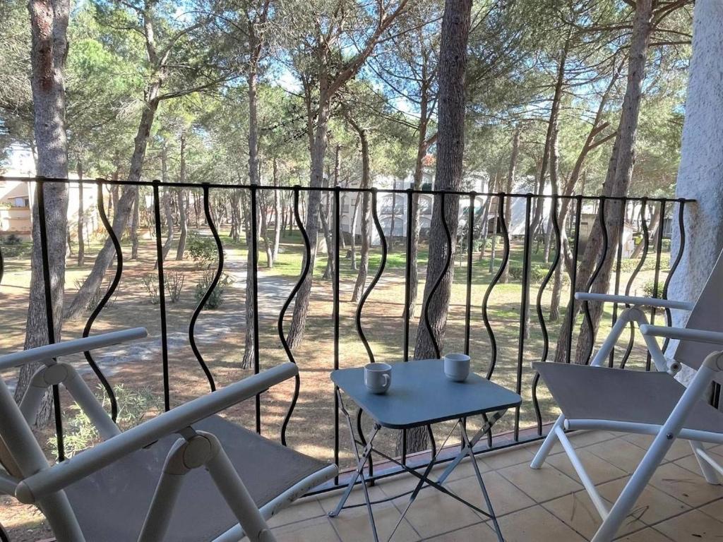 une terrasse avec des chaises, une table et des arbres dans l'établissement Appartement studio cabine - Argelès-sur-Mer AR530-027, à Argelès-sur-Mer