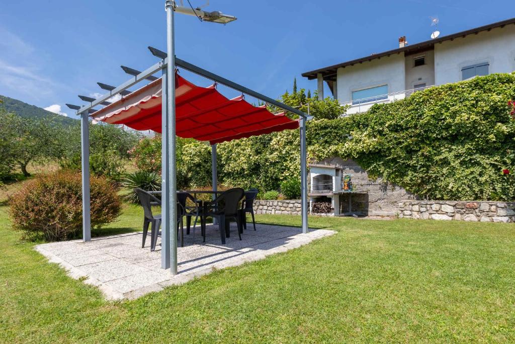 a patio with a table and chairs under a red canopy at Apartment in Tremosine - Gardasee 22253 in Tremosine Sul Garda