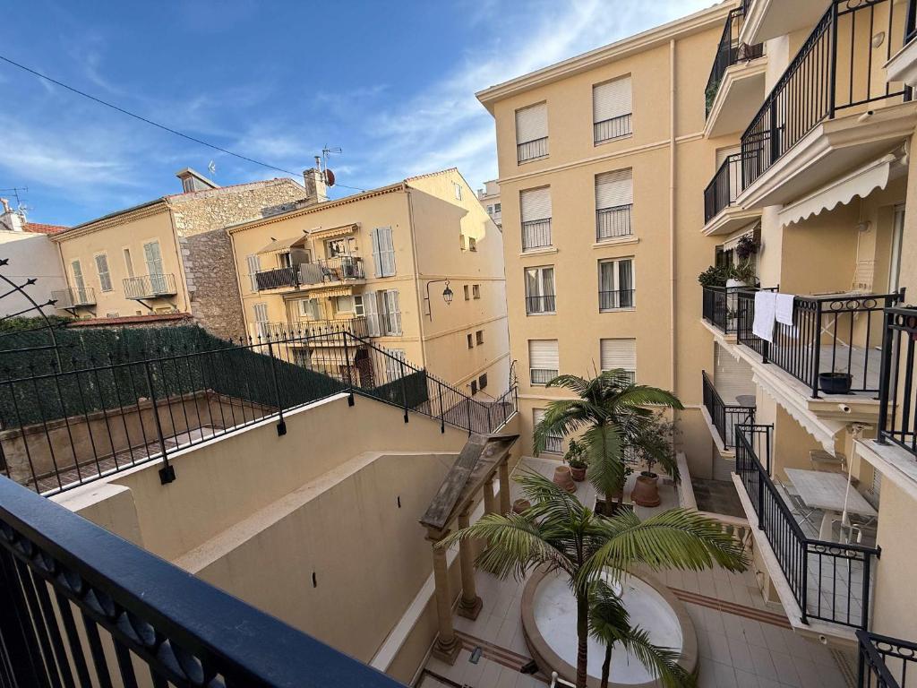 - un balcon offrant une vue sur un bâtiment avec des palmiers dans l'établissement B051-Bel appartement au centre deux chambres et parking securise, à Cannes