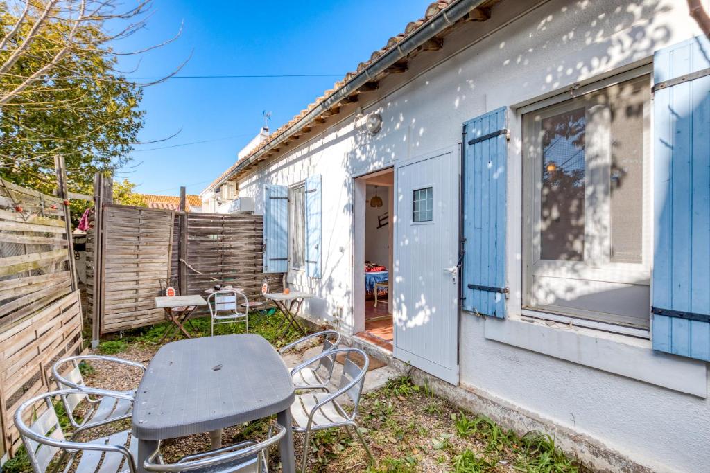une petite maison blanche avec des chaises et une table dans l'établissement L'Aigrette, à Saintes-Maries-de-la-Mer