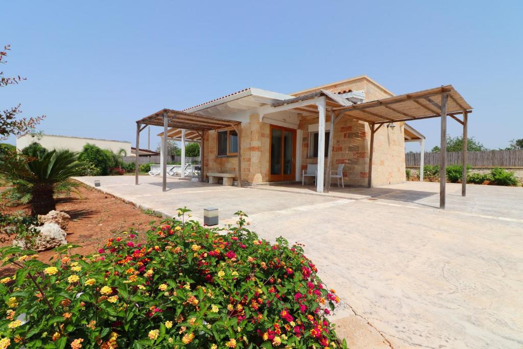un petit bâtiment avec des fleurs devant lui dans l'établissement Villetta Marechiaro, à Marina di Pescoluse