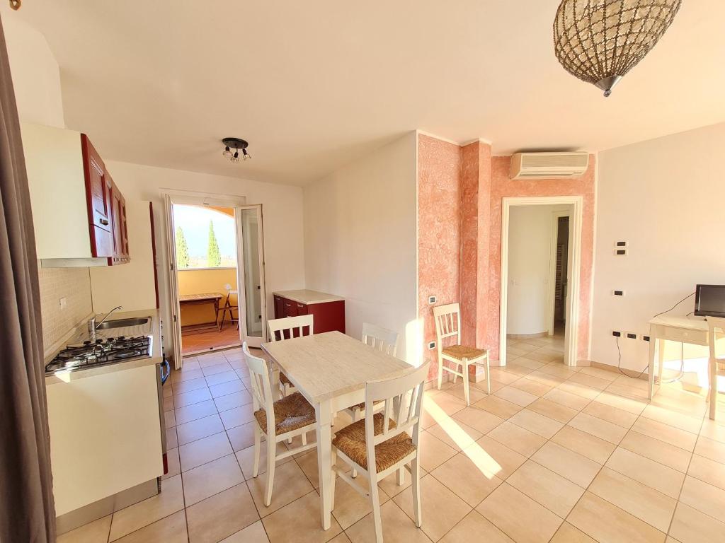 a kitchen and dining room with a table and chairs at Ombra Verde Residence e B&B in Follonica