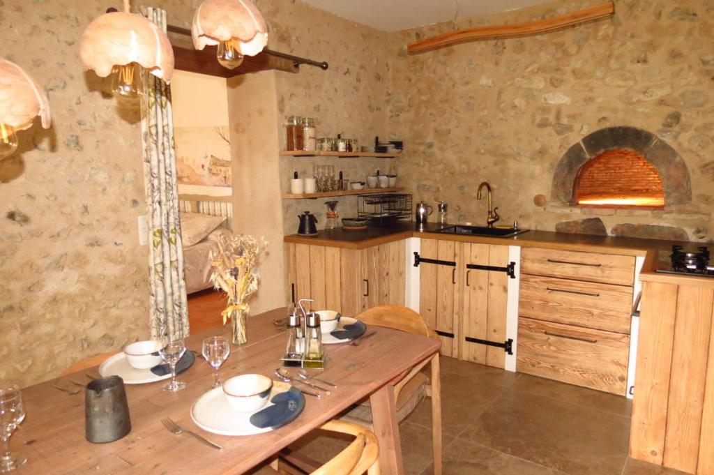 a kitchen with a wooden table in a room at Gîte écoconçu charmant proche zoo de la Flèche in Clermont-Créans
