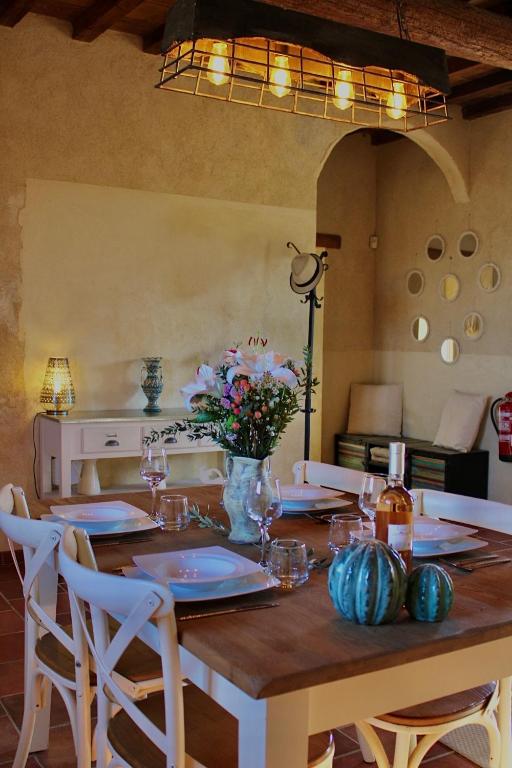 une table de salle à manger avec un vase de fleurs dessus dans l'établissement Mas de l'Hermitage, à Moulès