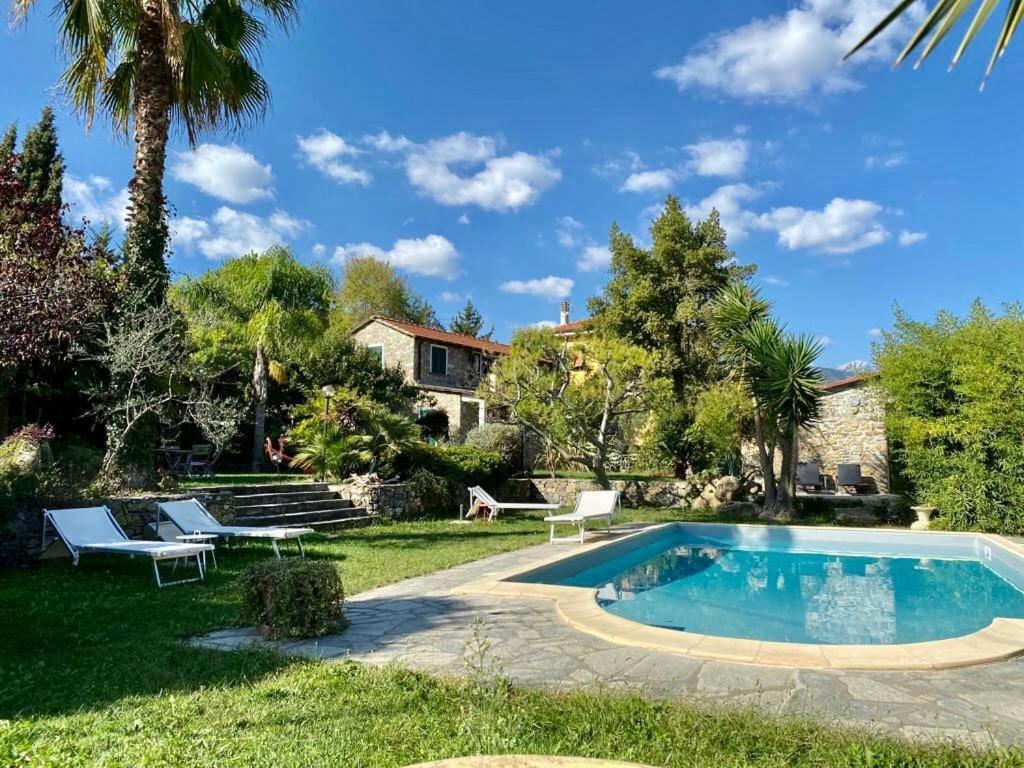 a backyard with a swimming pool and a house at Casa Didun -apart Bartume' in Dolcedo