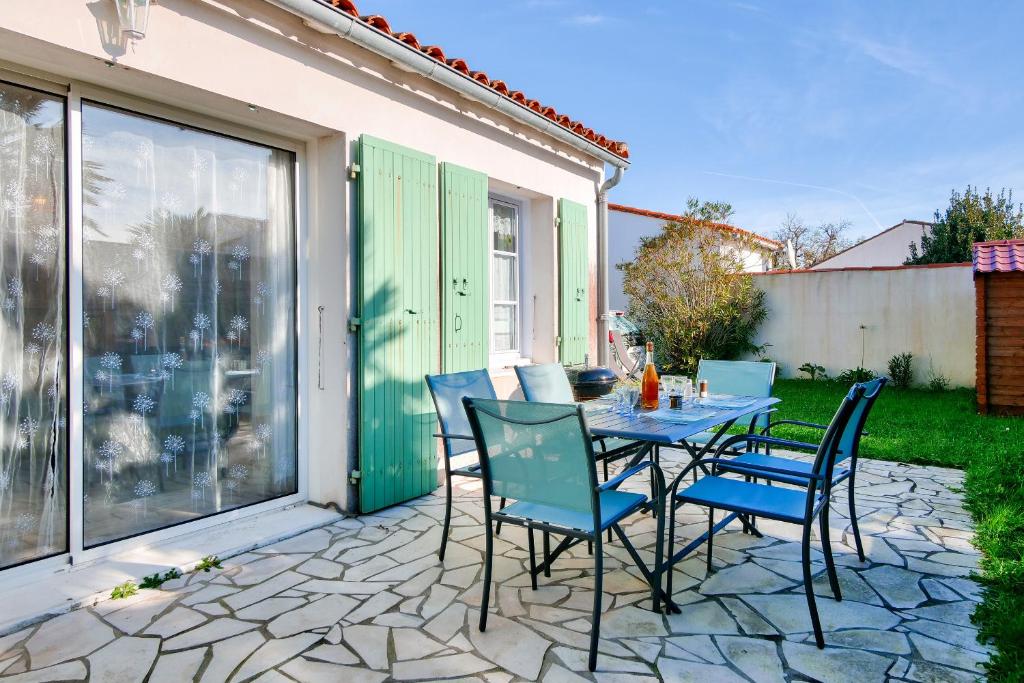 une terrasse en pierre avec une table et des chaises. dans l'établissement La Couarde sur Mer, maison pour 6 personnes, à La Couarde-sur-Mer