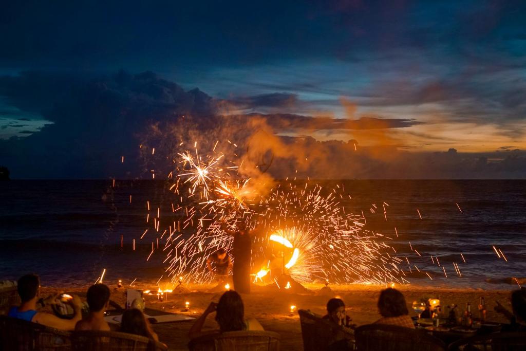a crowd of people watching a fire show on the beach at InterContinental Phuket Resort by IHG in Kamala Beach