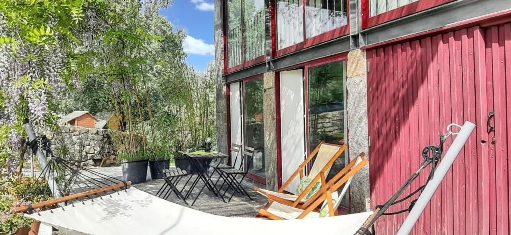 eine Sitzgruppe außerhalb eines roten Gebäudes in der Unterkunft Charming House in Covelas with Shared Pool in Póvoa de Lanhoso