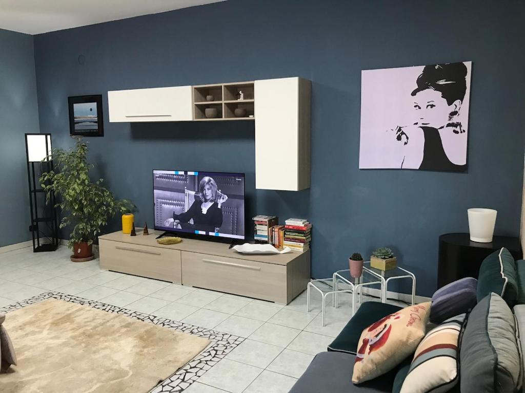 a living room with a couch and a flat screen tv at I Due Gelsi Appartamento Blu Cobalto in Monte San Giusto