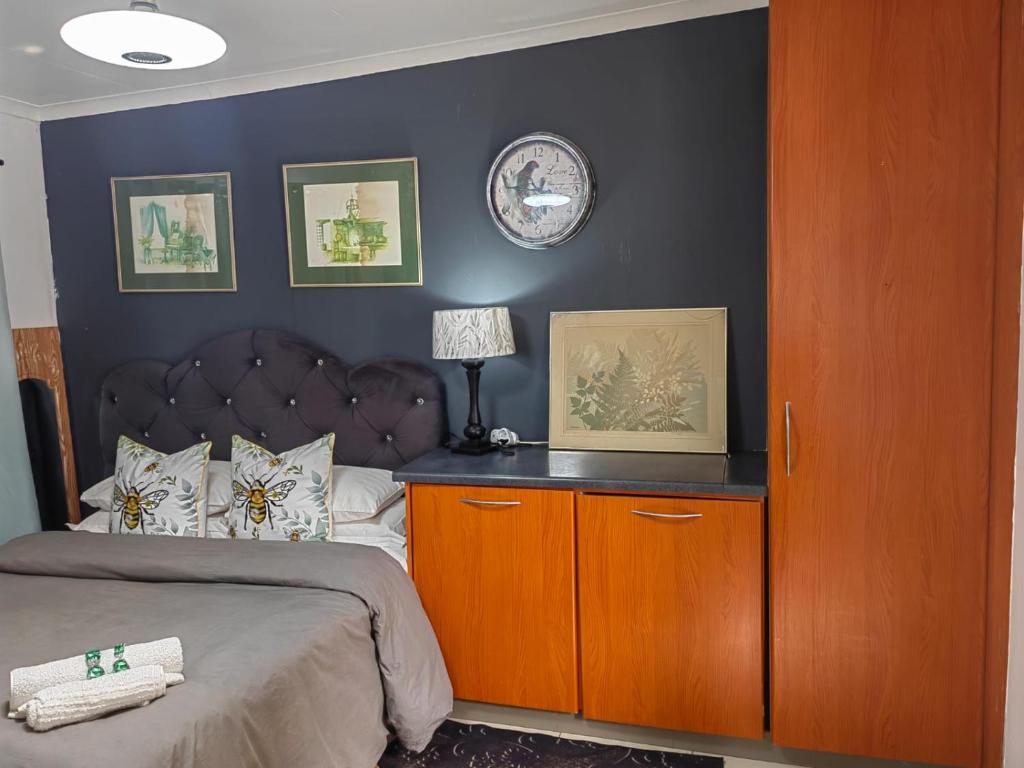 a bedroom with a large bed with a brown headboard at Private condo in secure area in Cape Town