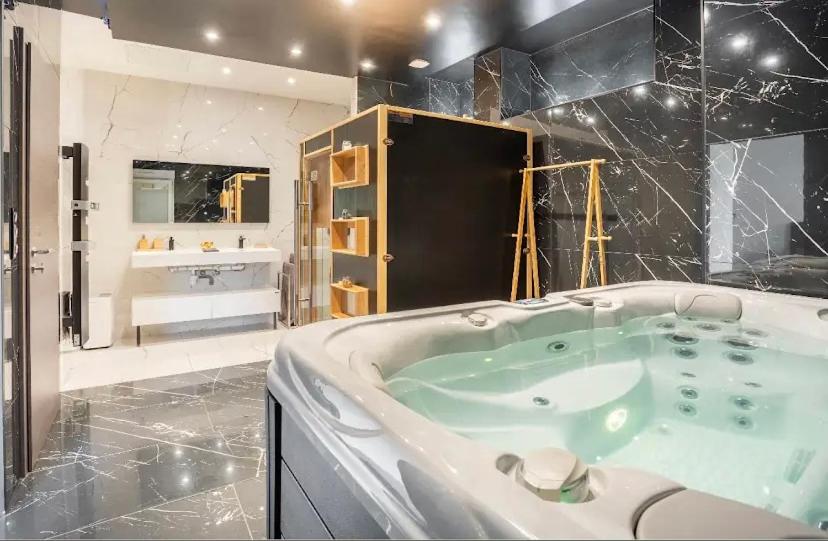 une grande salle de bain avec une baignoire et un lavabo dans l'établissement Septième 7 Sens, à Jarville-la-Malgrange