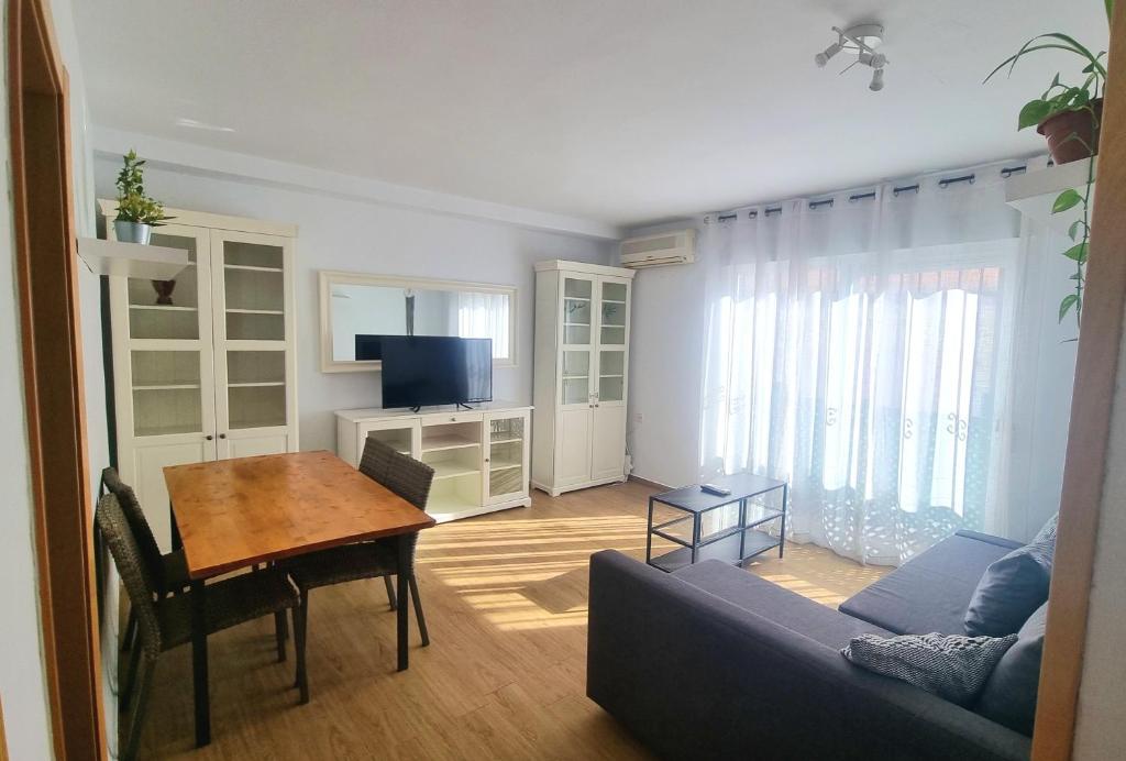 a living room with a table and a blue couch at Nice apartment in the center of Seville in Seville