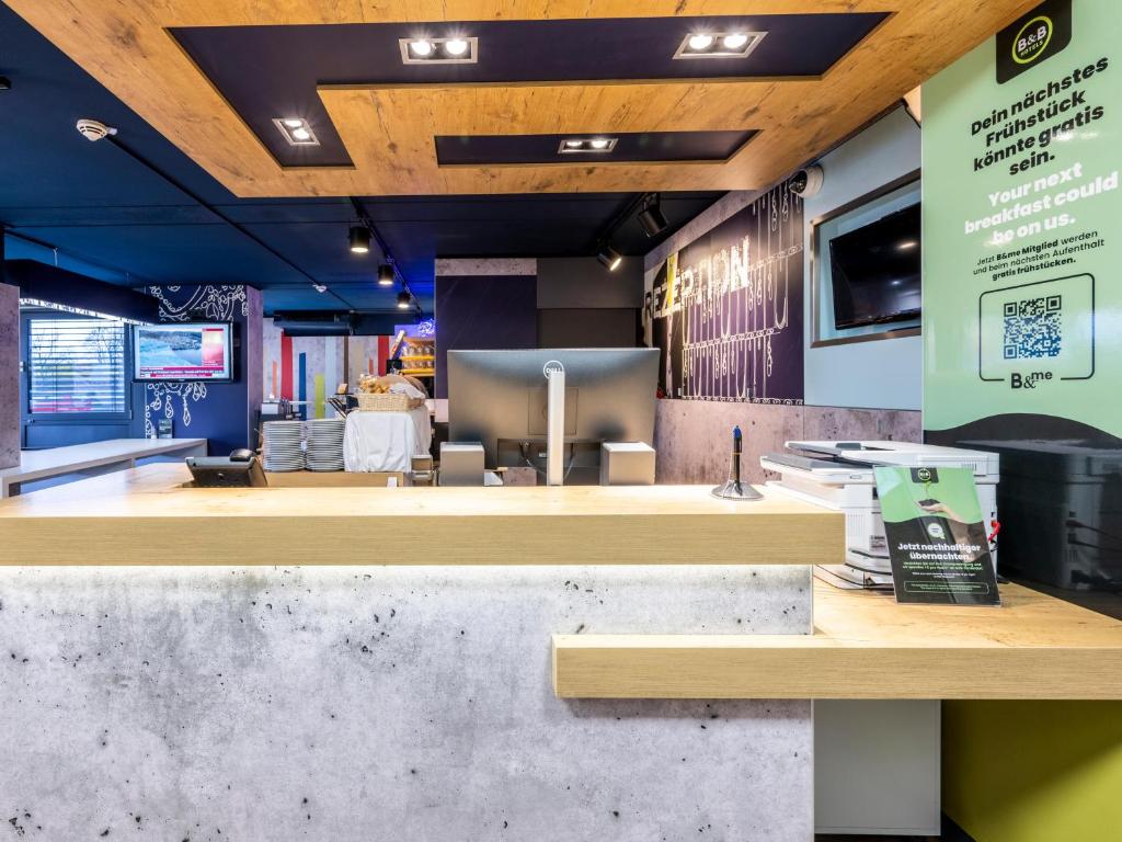 a fast food restaurant with a counter with a table at B&B HOTEL Dortmund-Airport in Holzwickede