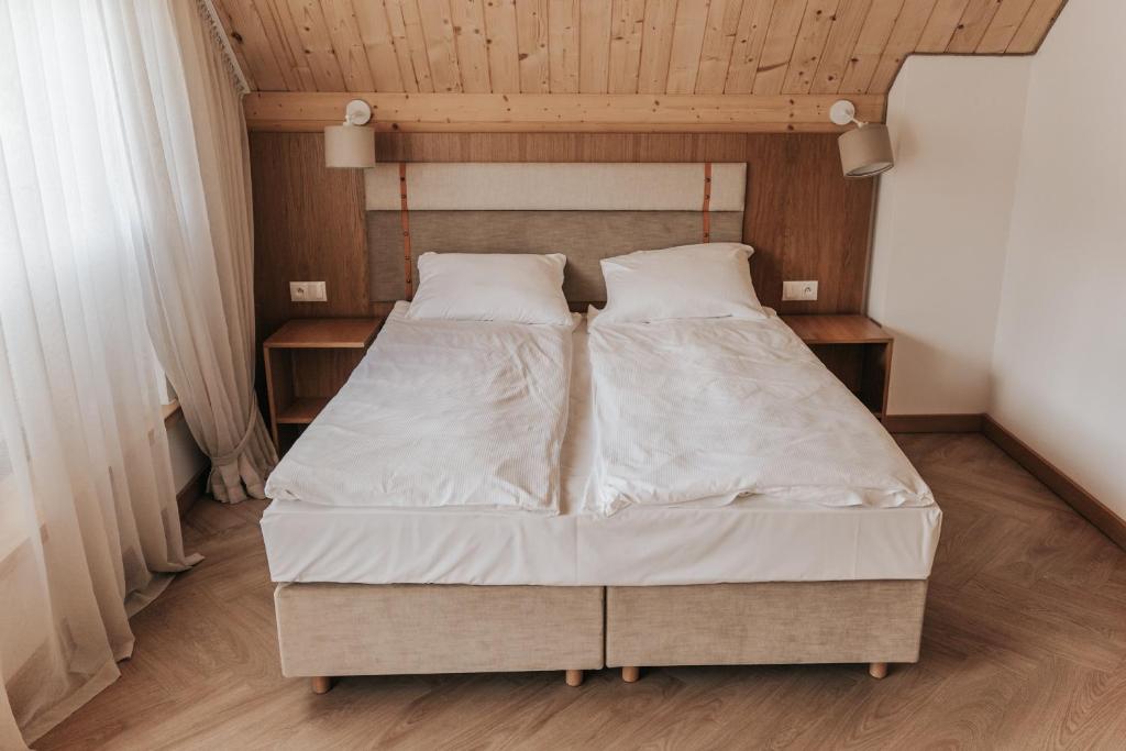 łóżko z białą pościelą i poduszkami w sypialni w obiekcie Jabłonki Resort&Spa w mieście Jabłonki
