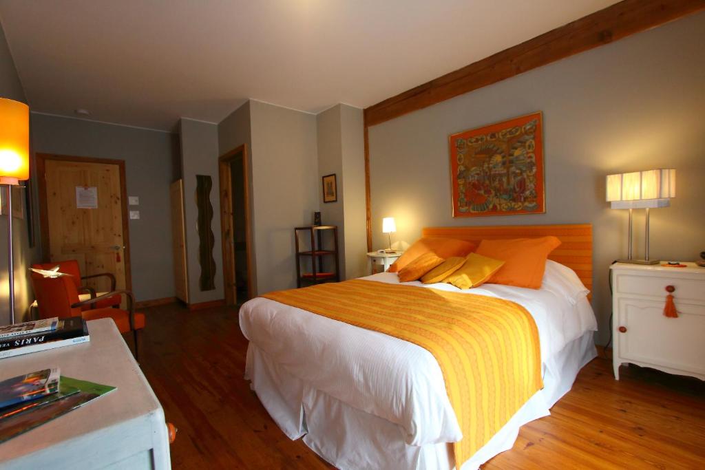ein Schlafzimmer mit einem großen Bett mit orangefarbenen und gelben Kissen in der Unterkunft Escale du Nord in Mont-Tremblant