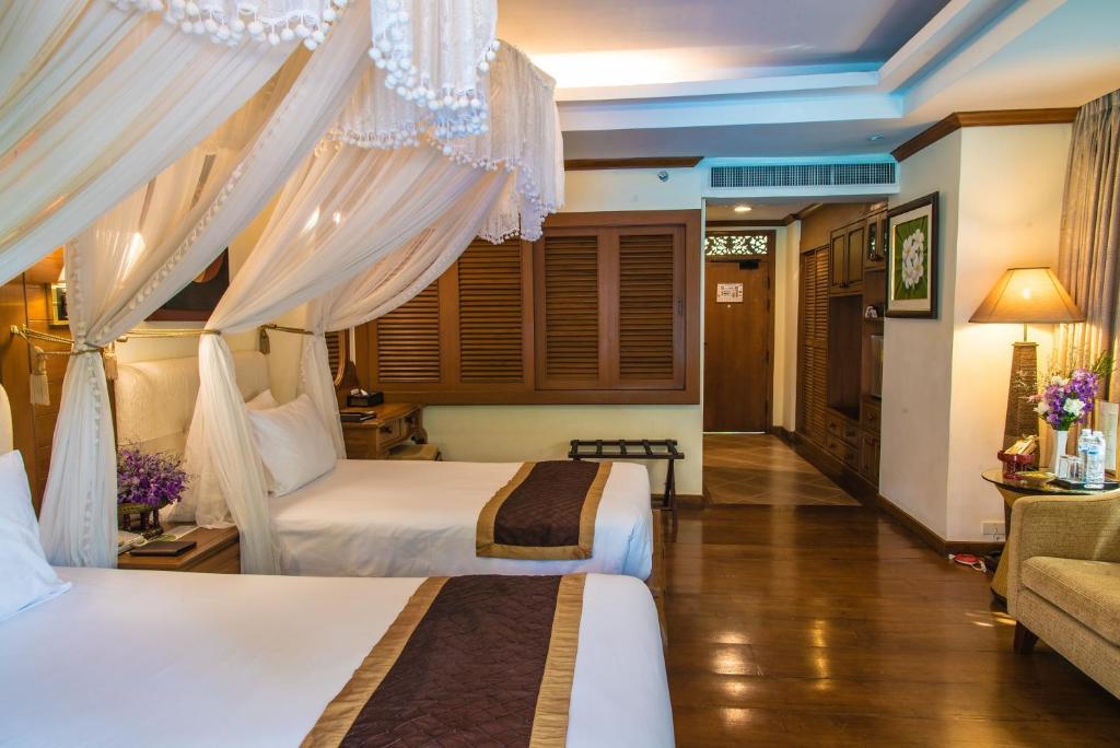 a hotel room with two beds and a couch at Khum Phaya Resort & Spa Boutique Collection in Chiang Mai