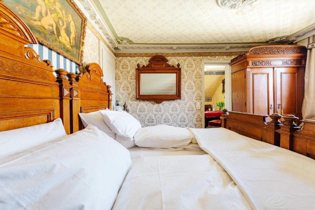 1 Schlafzimmer mit 2 Betten und einem Kopfteil aus Holz in der Unterkunft Villa Charlotte in Bad Harzburg