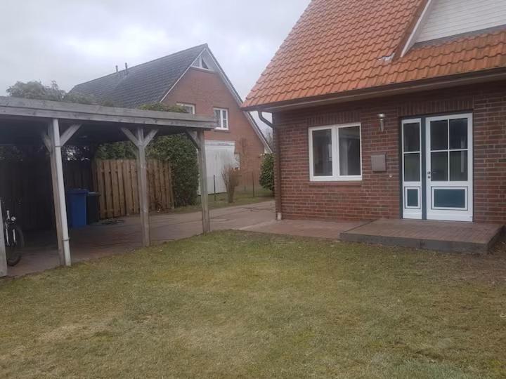 a brick house with a patio and a yard at Haus 6-12P - 6Zi - Aurora Hamburg in Wenzendorf