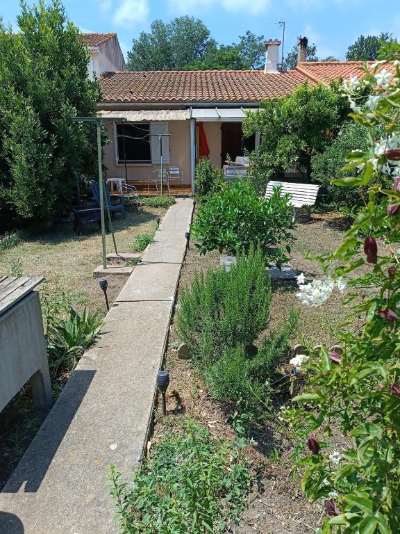 un jardin avec une passerelle en face d'une maison dans l'établissement Sea & Mountain House, à Saint-André