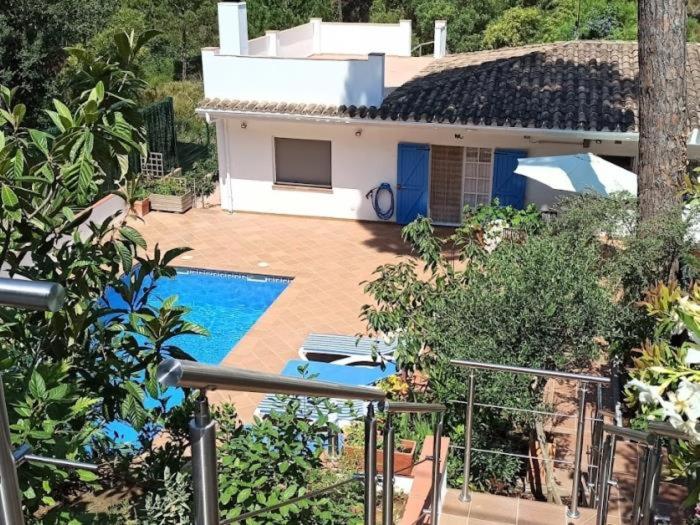 a house with a swimming pool in front of it at Flores in Begur