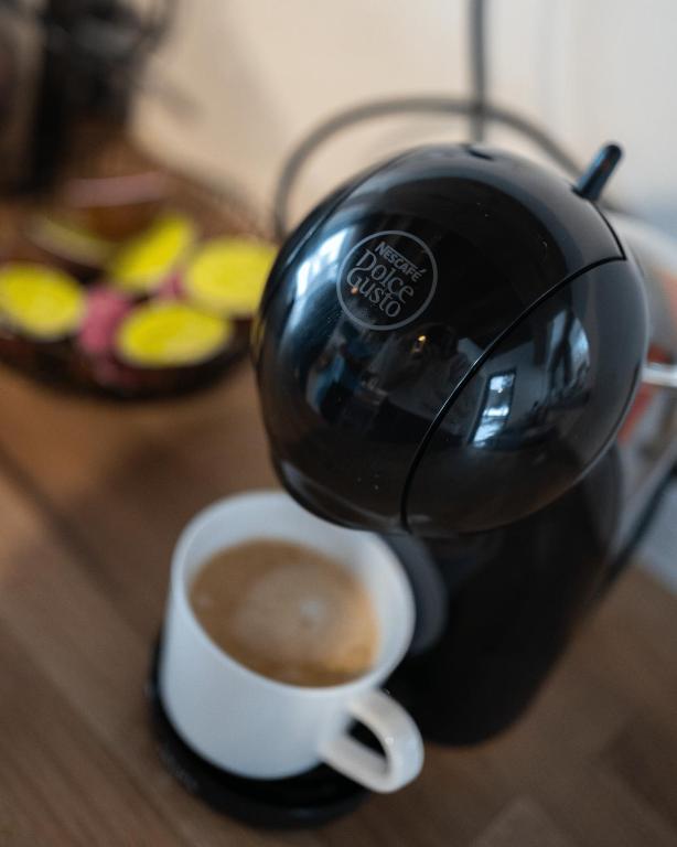 una tazza di caffè su un tavolo con un bollitore per il tè di Srub v Odeři a Hroznětín